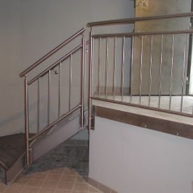 Treppengeländer mit Handlauf in Kupfer mit Metalltreppe, die in einem Haus einen Höhenunterschied ausgleicht